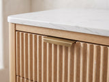 Close-up of the Palmanova 62-Inch Natural Wood and White Stone 6-Drawer Dresser: the brass edge pull on a reeded drawer front under the white stone top