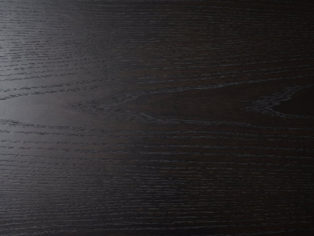 Close-up of the Palmi 70-Inch Black Oak Veneer Dining Set with 4 Boucle Chairs: the black-stained oak veneer top with its open grain