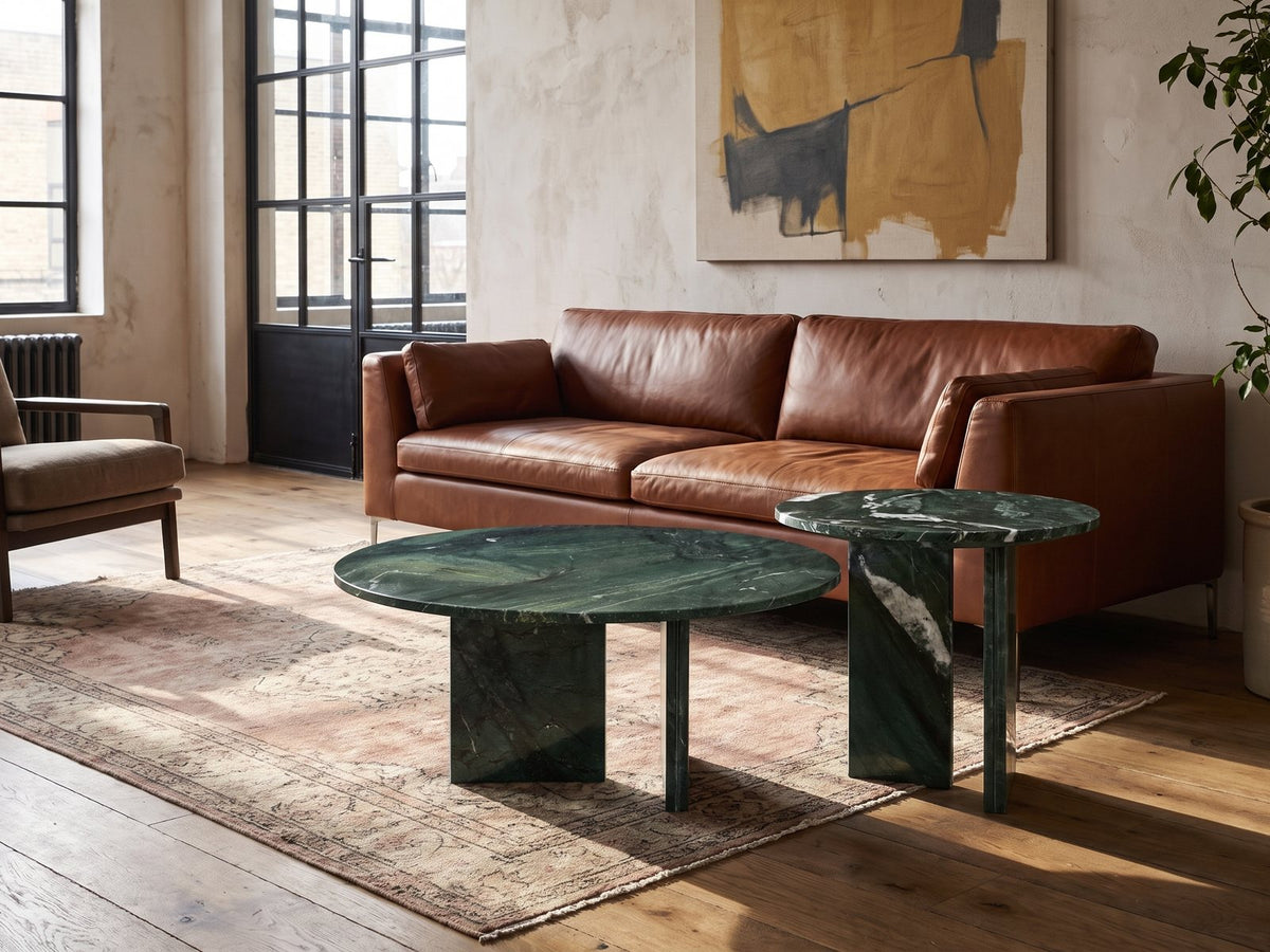 Panarea Verde Marble Nesting Coffee Tables, Set of 2 on a vintage rug in front of a leather sofa in an industrial loft