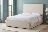 Penne ivory canvas bed against a dusty blue-green panelled wall in a Charleston townhouse bedroom with tall windows and a cream wool rug