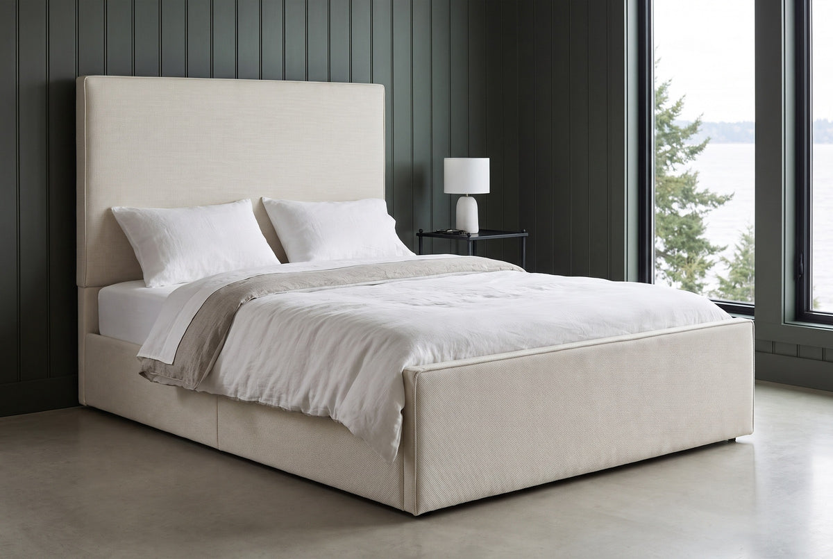 Penne ivory canvas bed against charcoal-green vertical panelling in a Seattle waterfront bedroom, a tall window onto grey water and evergreens at the right