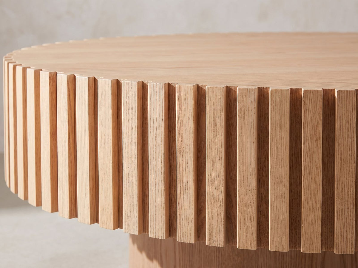 Close-up of the Pesaro Ash Veneer Fluted Pedestal Coffee Table: the ring of ash slats under the notched rim of the top