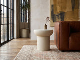 Pescocostanzo Cream Textured Fiberglass Mushroom Side Table beside a leather sofa in an industrial loft