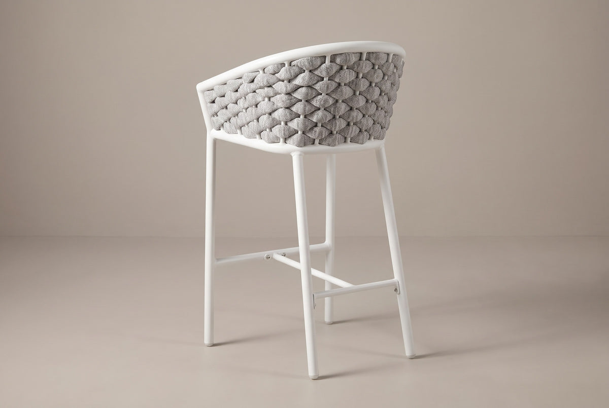A Petralia stool from behind: the grey rope barrel back, the white top band, the slim round legs and the rails between them