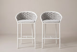 The two Petralia counter stools seen straight from the front: woven barrel backs, pale grey cushions, slim round legs and the footrest rails