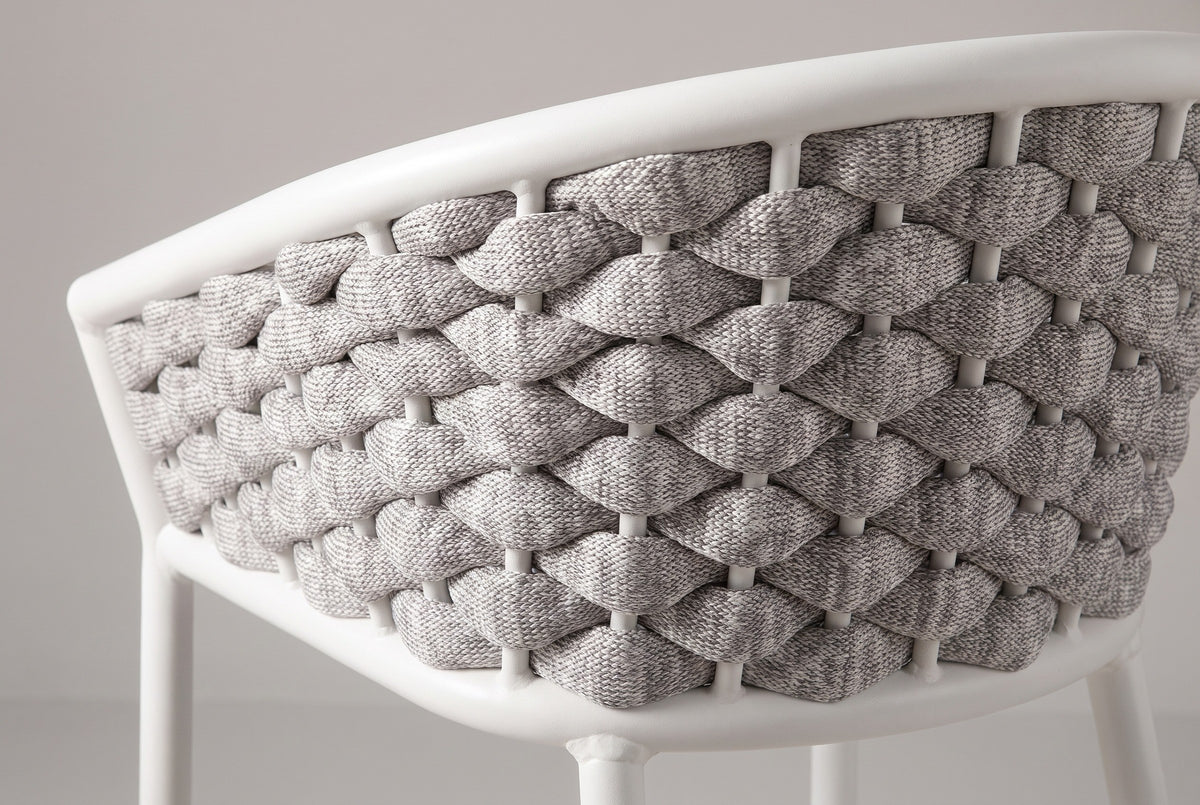 Close-up of the grey-and-white woven rope back of a Petralia stool and its white aluminum top band