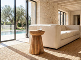 Petroio Fluted Mango Mushroom Side Table beside a linen sofa in a poolside villa