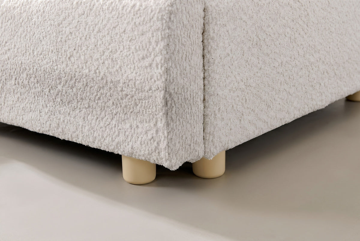 Close-up of the Pietrabbondante bed where the ivory boucle rail meets two short round feet
