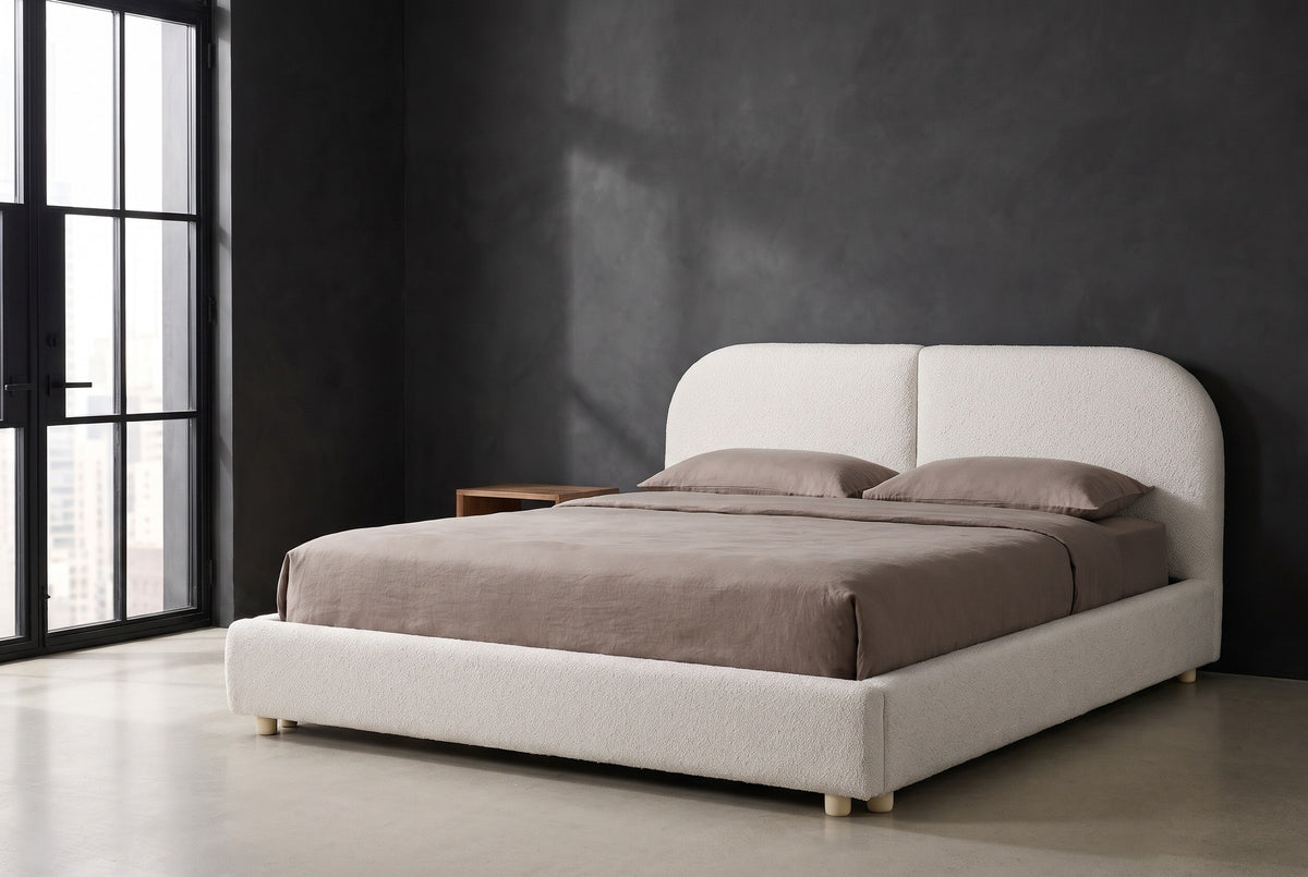 Pietrabbondante ivory boucle bed against a charcoal limewash wall in a Chicago loft, a tall black steel window at the left