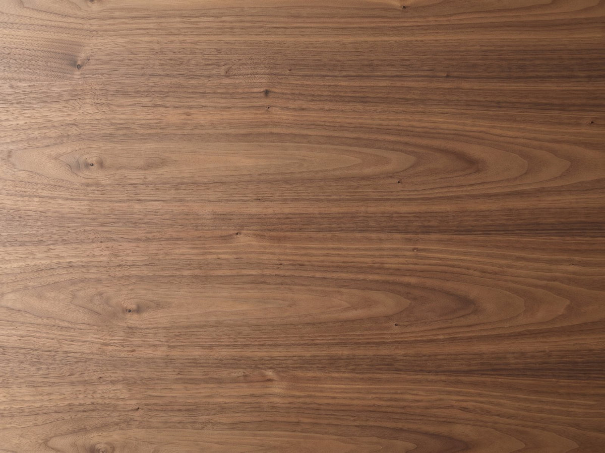 Close-up of the Pietrapertosa Walnut Pedestal Side Table: the walnut grain of the pebble-shaped top
