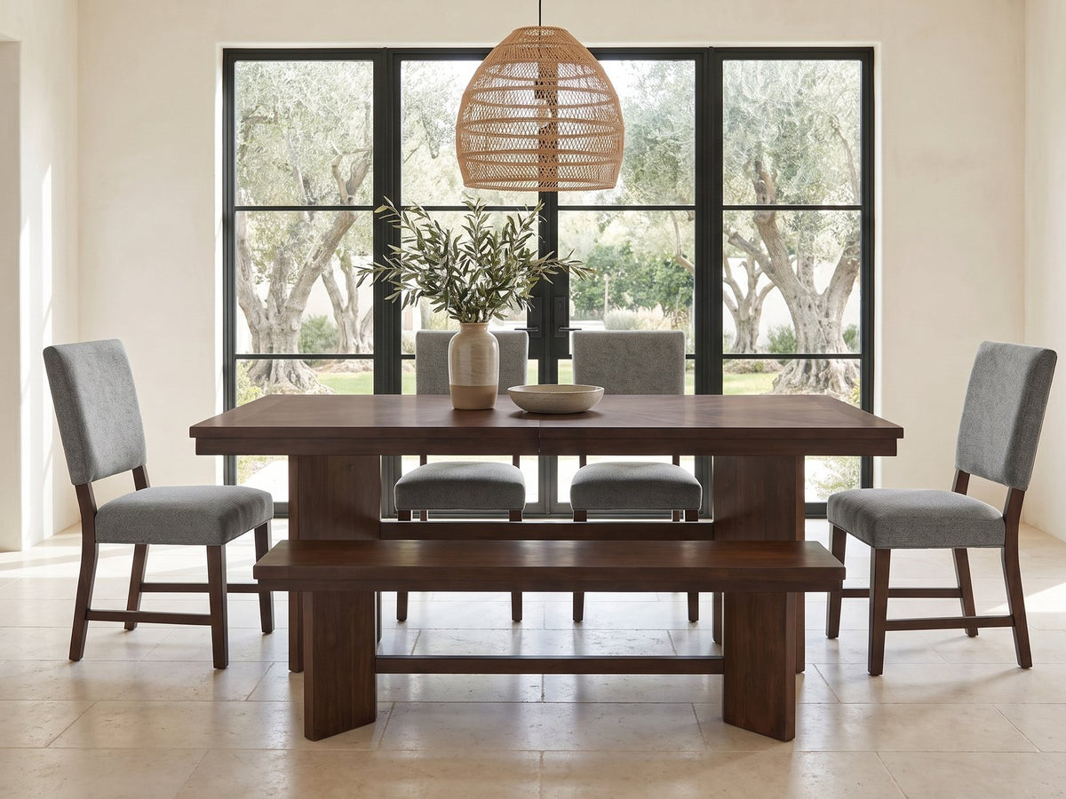 Pizzo 76-Inch Walnut Veneer Extending Trestle Dining Set with Bench and 4 Chairs in a sunlit villa dining area with olive trees outside