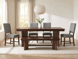 Pizzo 76-Inch Walnut Veneer Extending Trestle Dining Set with Bench and 4 Chairs in a bright plaster dining room with linen curtains