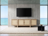 Polignano Oak and Cane Media Console under a wall-mounted screen in an oceanfront glass house