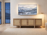 Polignano Oak and Cane Media Console under a screen showing a snowy landscape on a winter evening