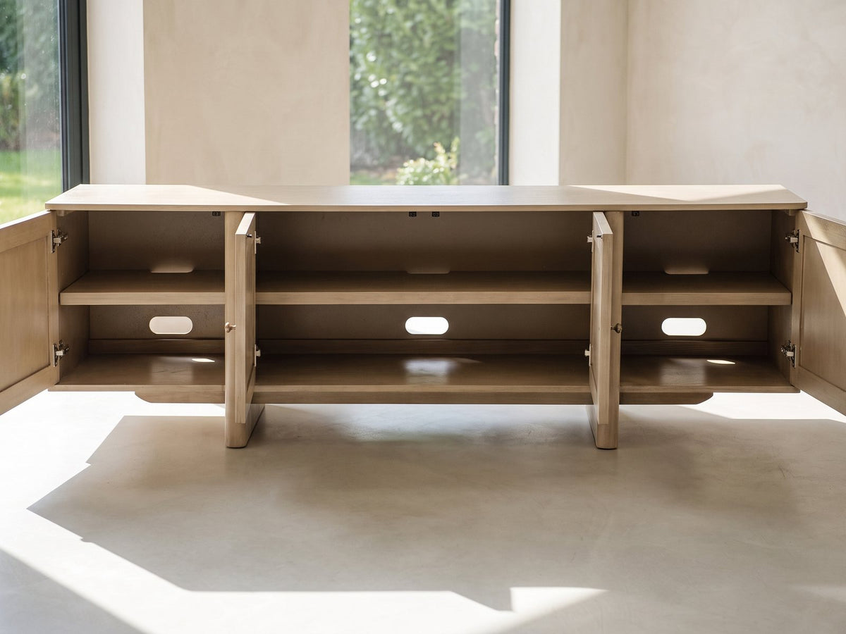 Close-up of the Polignano Oak and Cane Media Console: the four doors open showing the adjustable shelves and cable openings inside