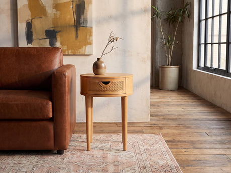 Pontedera Cane and Wood Round Side Table beside a leather sofa in an industrial loft