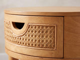 Close-up of the Pontedera Cane and Wood Round Side Table: the cane drawer front with its half-moon pull
