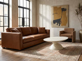 Ponza Milk White Fiberglass Pebble Coffee Table on a vintage rug in front of a leather sofa in an industrial loft