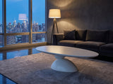 Ponza Milk White Fiberglass Pebble Coffee Table on a wool rug in front of a velvet sofa in a city penthouse at blue hour