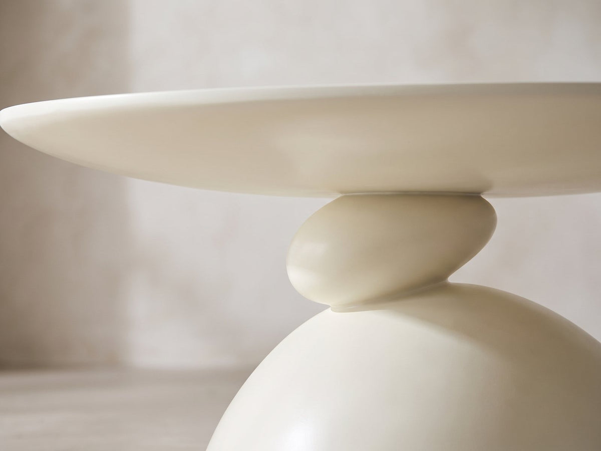 Close-up of the Ponza Milk White Fiberglass Pebble Coffee Table: the two stacked pebbles of the base under the top