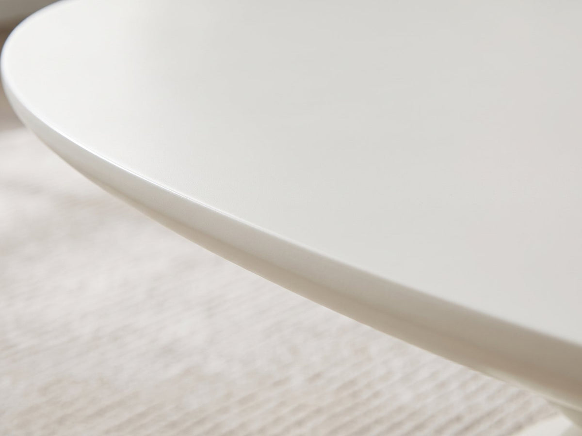 Close-up of the Ponza Milk White Fiberglass Pebble Coffee Table: the softly rounded satin edge of the milk white top