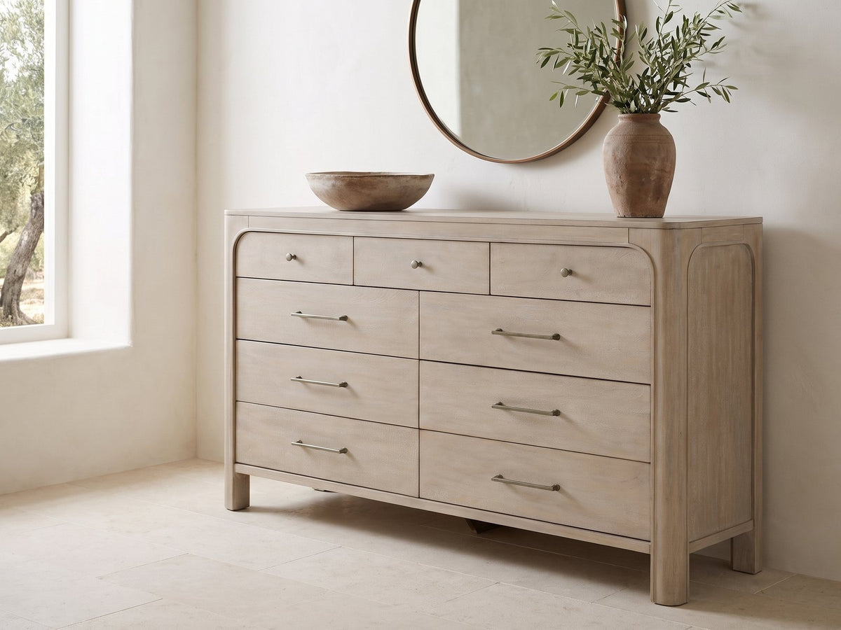 Portogruaro 70-Inch Weathered Mango 9-Drawer Dresser under a round bronze mirror in a villa bedroom