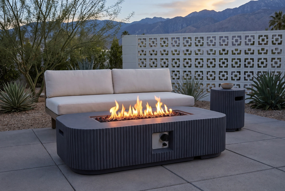 Portopalo fire pit lit on a mid-century patio in Palm Springs at blue hour, a white breeze-block wall and the mountains behind (sofa not included)