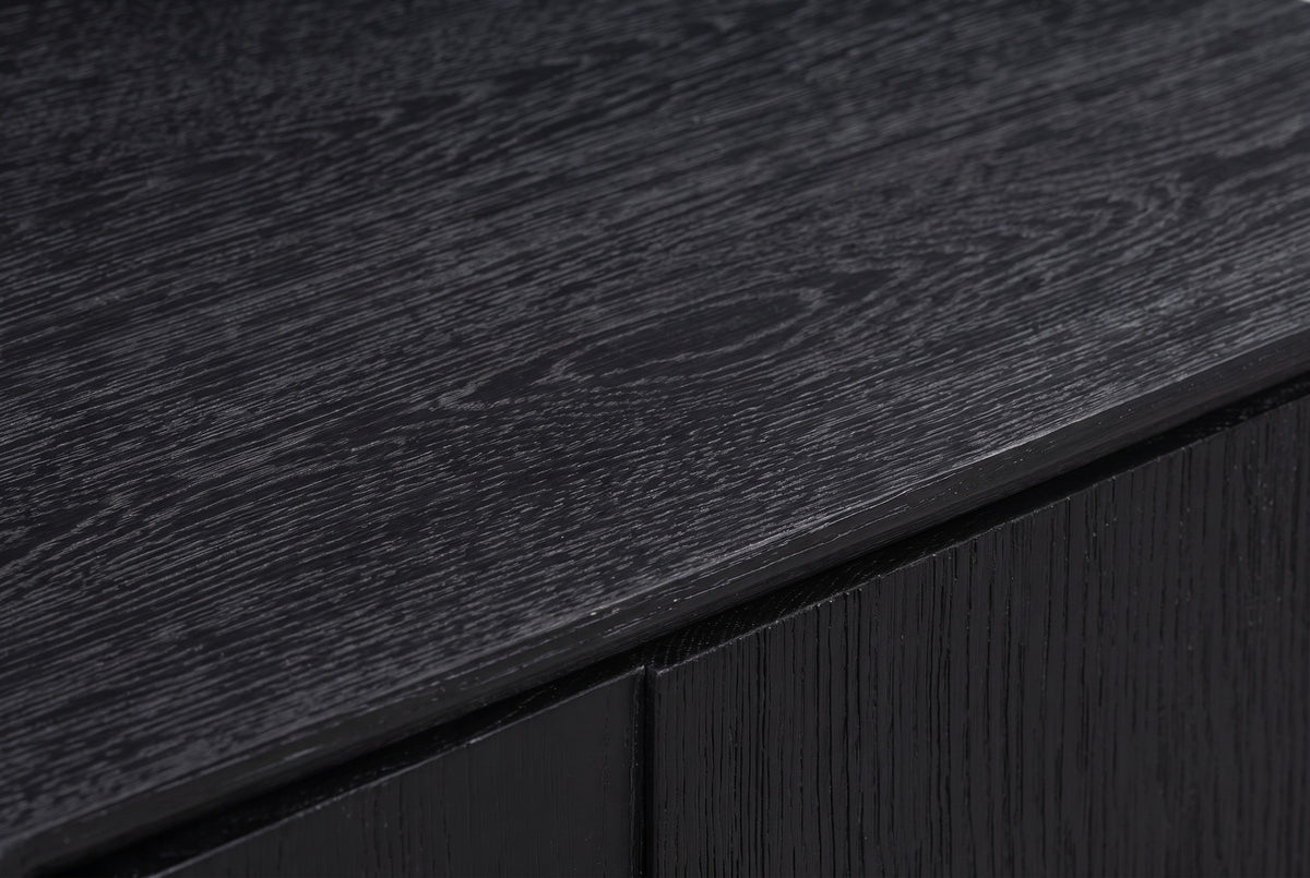 Close-up of the black wire-brushed oak on the Posada nightstand: wavy charcoal-grey grain on a deep matte black top