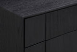 The upper corner of the Posada nightstand: the brushed black oak top and the vertical oak blocks of the drawer fronts