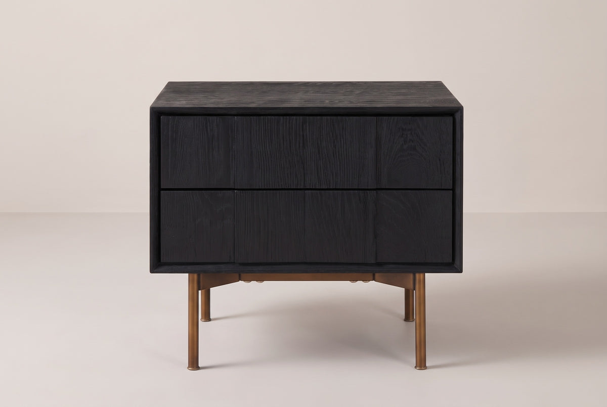 The Posada nightstand in black wire-brushed oak, front view on a light studio backdrop