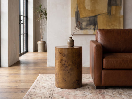 Potenza Walnut Burl Pillar Side Table beside a leather sofa in an industrial loft