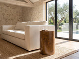 Potenza Walnut Burl Pillar Side Table beside a linen sofa in a poolside villa
