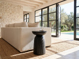 Presicce Black Mango Scalloped Pedestal Side Table beside a linen sofa in a poolside villa
