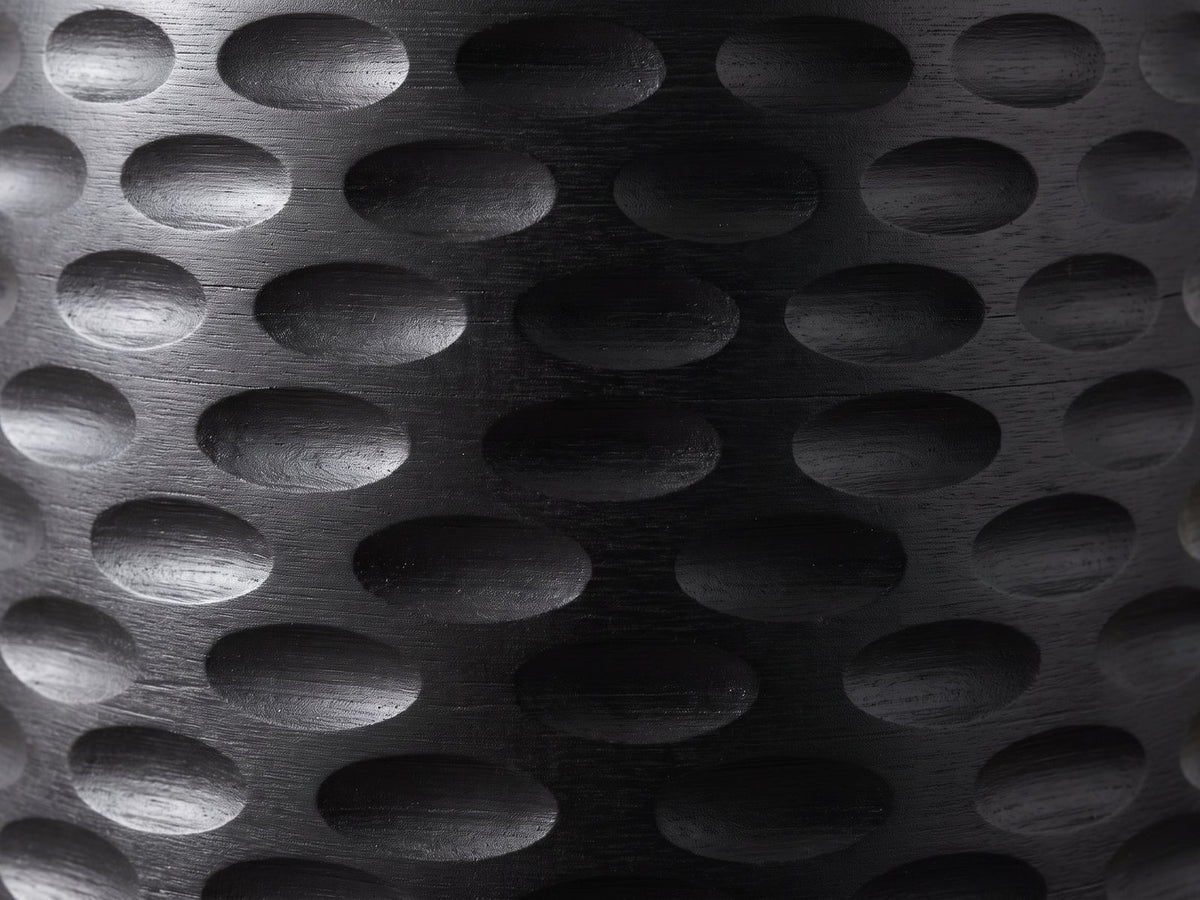 Close-up of the Presicce Black Mango Scalloped Pedestal Side Table: the small hand-carved oval scoops of the base