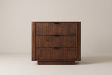 The Pula nightstand in dark walnut, front view on a light studio backdrop
