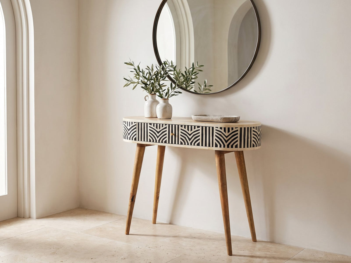 Pulsano Bone Inlay Oval Console Table under a round mirror in a travertine entryway
