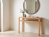 Putignano Wrapped Rattan Two-Tier Console Table under a round mirror in a travertine entryway