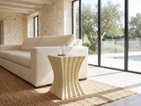 Racale Cream Fiberglass Pleated Side Table beside a linen sofa in a poolside villa