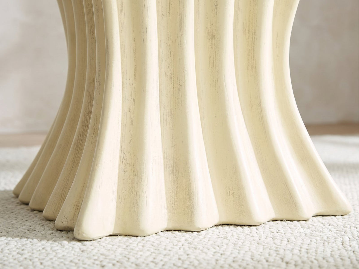 Close-up of the Racale Cream Fiberglass Pleated Side Table: the rounded pleats flaring out at the foot
