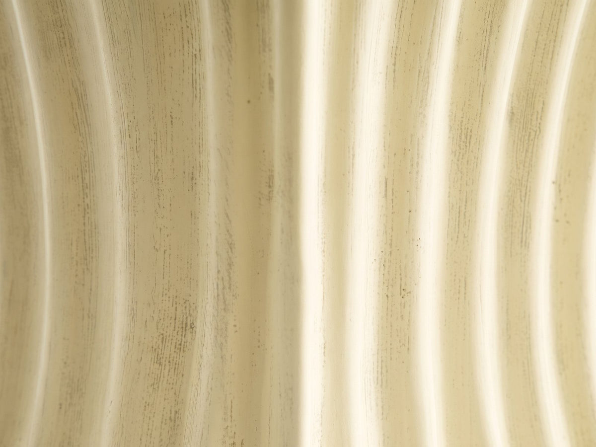 Close-up of the Racale Cream Fiberglass Pleated Side Table: the aged cream milk-paint finish over the pleats