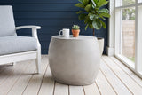 Racalmuto concrete barrel side table with a white mug and a small succulent on a screened porch in Austin, Texas, a navy-blue painted wall and whitewashed floorboards (chair and decor not included)