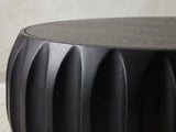 Close-up of the Radda Black Carved Wood Drum Coffee Table: the carved black wood scallops under the rim of the top