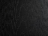Close-up of the Radda Black Carved Wood Drum Coffee Table: the open-pore black ash grain of the top