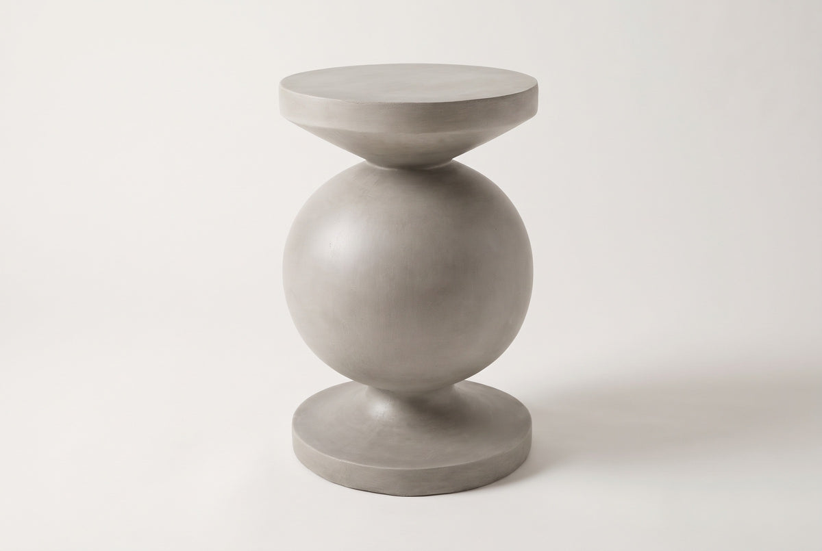 The Raffadali light grey concrete sphere pedestal side table, three-quarter view on a light studio backdrop