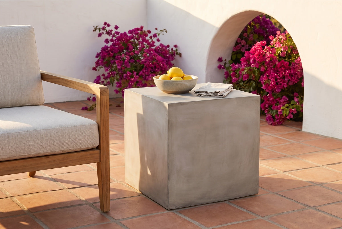 Realmonte concrete cube side table with a bowl of lemons on a terracotta tile terrace in Santa Barbara at golden hour, a white plaster arch and bougainvillea behind (chair and decor not included)
