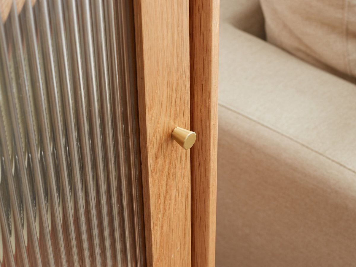 Close-up of the Recco Solid Oak Reeded Glass Storage Cabinet: the brushed-brass door knob beside the reeded glass door