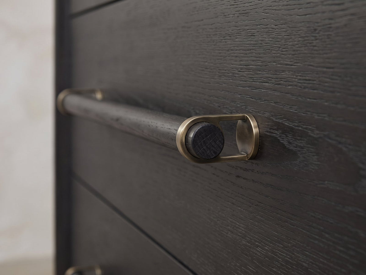 Close-up of the Recoaro 54-Inch Peppercorn Black 6-Drawer Dresser: the wooden dowel pull held in antique-brass loops on the black peppercorn elm drawer front