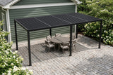 Regalbuto black louvered pergola over a round dining table on granite setts beside a sage-green house in Atlanta, hydrangeas and dogwoods around (furniture not included)