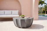 Ribera speckled gray coffee table on cream limestone in a Coral Gables pool loggia, a blush-pink stucco wall with an arch and a white outdoor sofa behind (sofa, bowl and napkins not included)