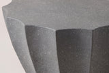 Close-up of the Ribera table: the speckled gray MgO cement at one point of the scalloped top, white flecks in the matte surface